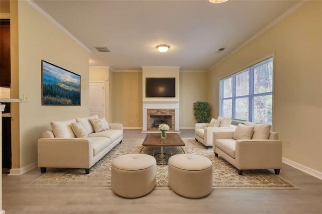 living room featuring baseboards, a fireplace, visible vents, and crown molding