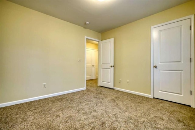 unfurnished bedroom featuring carpet flooring and baseboards