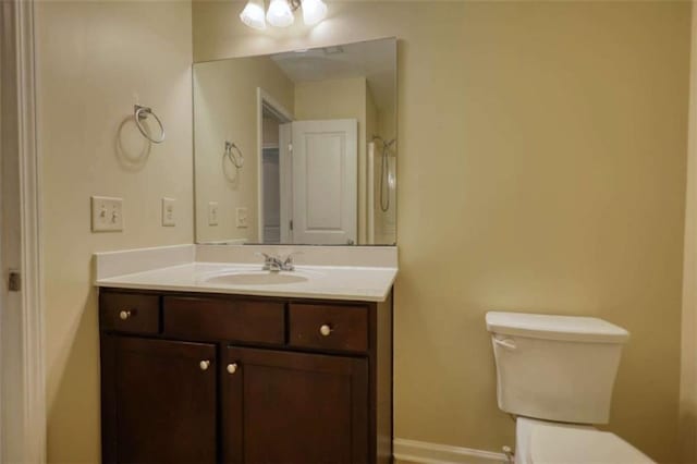 bathroom with vanity, toilet, and baseboards