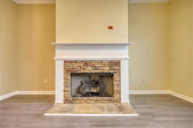 room details with crown molding, a fireplace, and wood finished floors