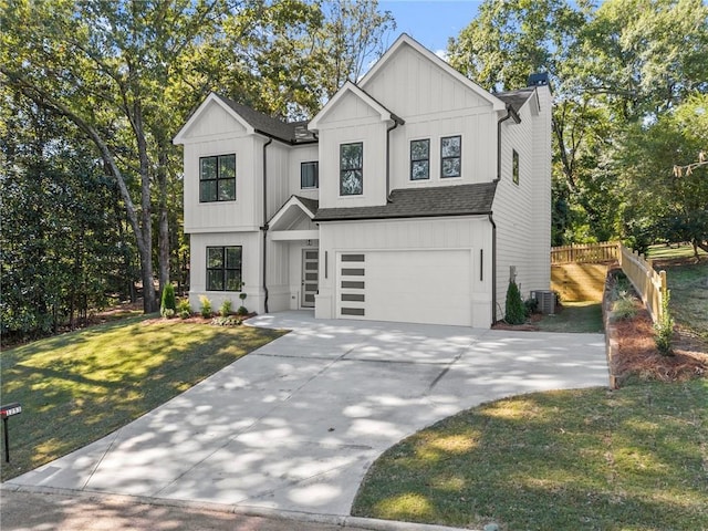 view of front facade with a front yard, central AC, and a garage