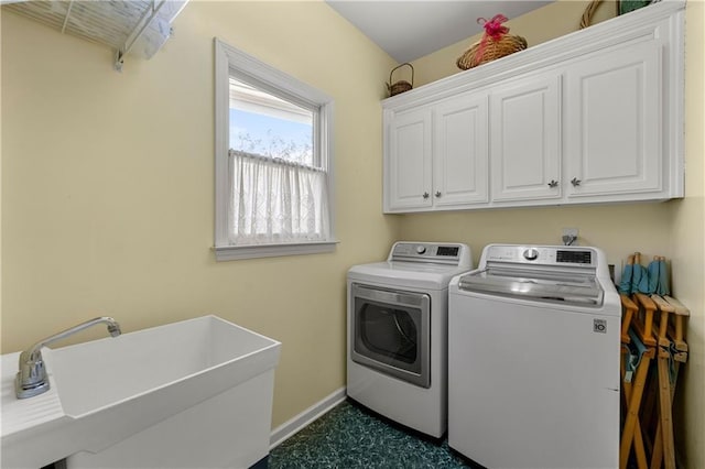 clothes washing area with separate washer and dryer, a sink, cabinet space, and baseboards