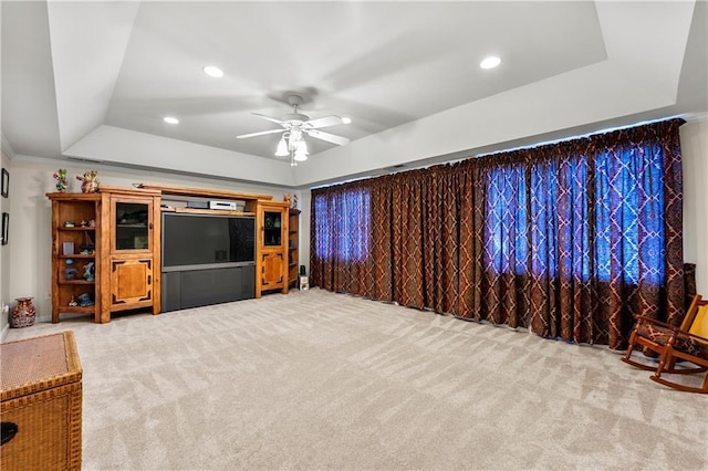 living room featuring light carpet, ceiling fan, a tray ceiling, crown molding, and recessed lighting