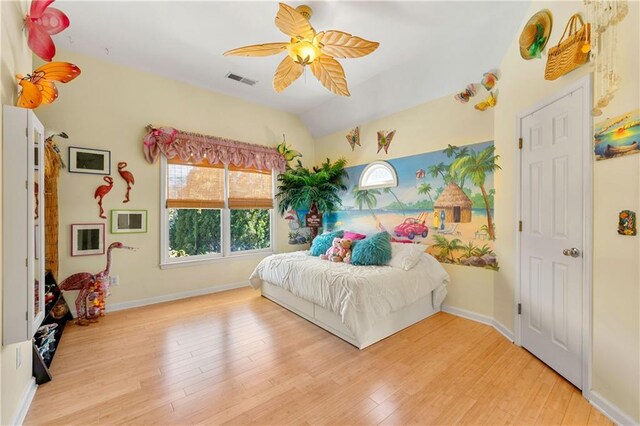 bedroom featuring ceiling fan, visible vents, vaulted ceiling, and wood finished floors