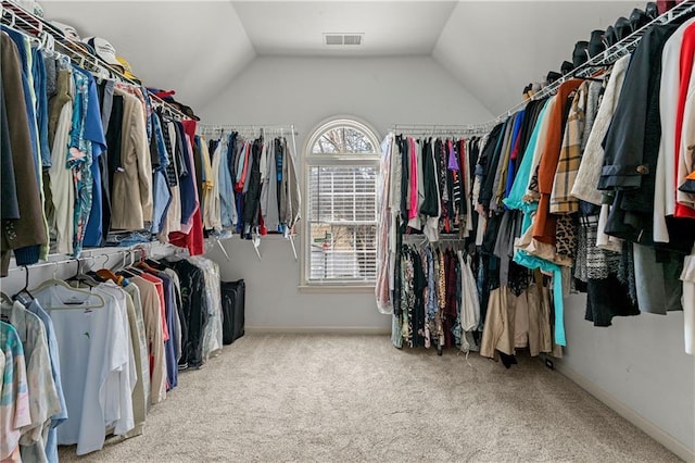 walk in closet with lofted ceiling, visible vents, and carpet