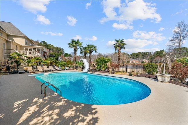 view of pool featuring a patio area, a fenced in pool, fence, and a water slide