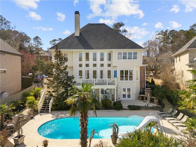 back of house with stairs, fence, a fenced in pool, and a patio