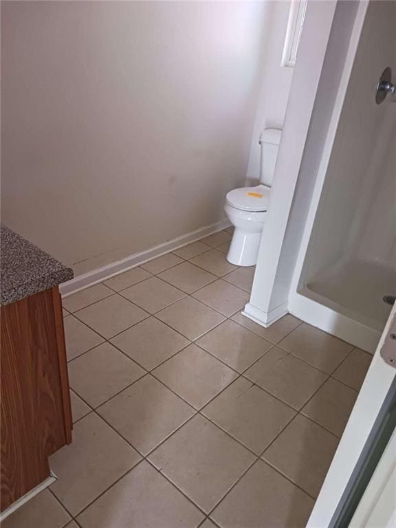 bathroom featuring tile patterned floors, walk in shower, and toilet