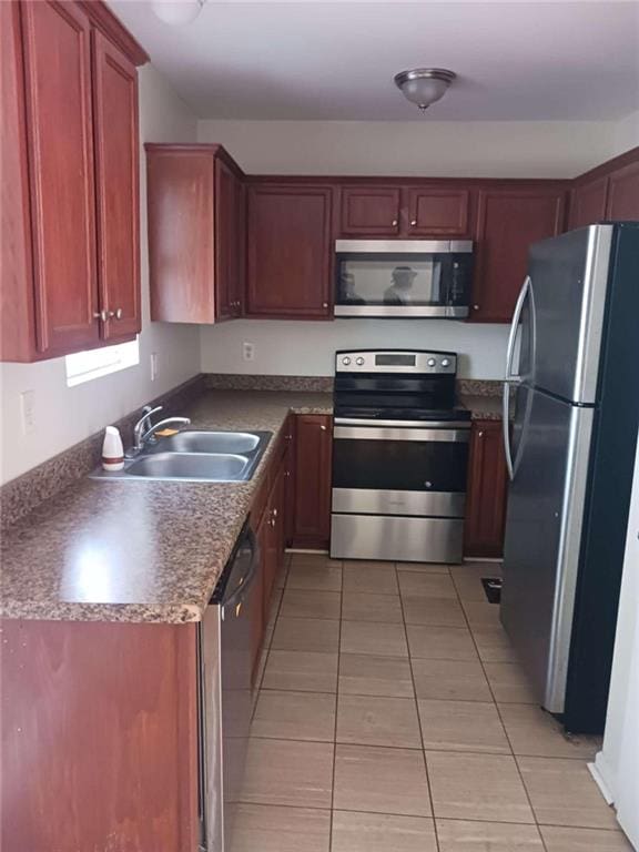 kitchen with light tile patterned flooring, stainless steel appliances, and sink