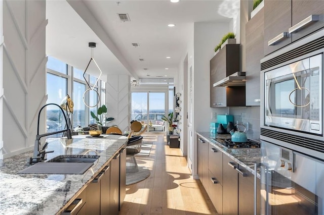 45 Ivan Allen Jr Blvd NW Unit 2505, Atlanta, GA 30308 - kitchen featuring modern cabinets, a sink, appliances with stainless steel finishes, light stone countertops, and recessed lighting