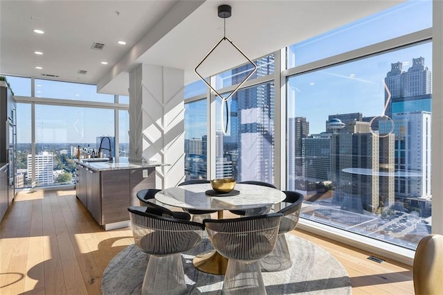 45 Ivan Allen Jr Blvd NW Unit 2505, Atlanta, GA 30308 - dining area with expansive windows, a city view, healthy amount of natural light, hardwood / wood-style flooring, and recessed lighting