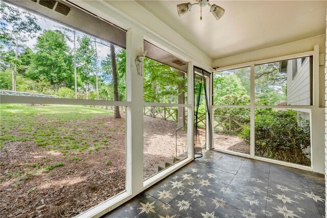 unfurnished sunroom featuring a ceiling fan