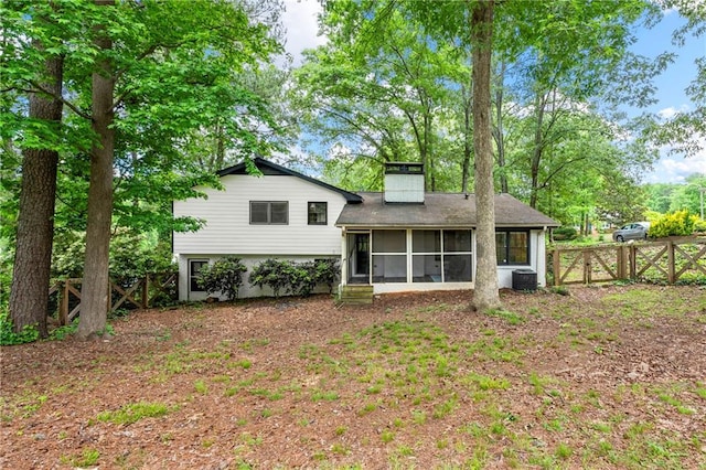 back of house with a sunroom, fence, a chimney, central AC unit, and a gate