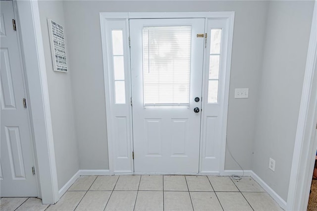 foyer entrance featuring light tile patterned floors and baseboards