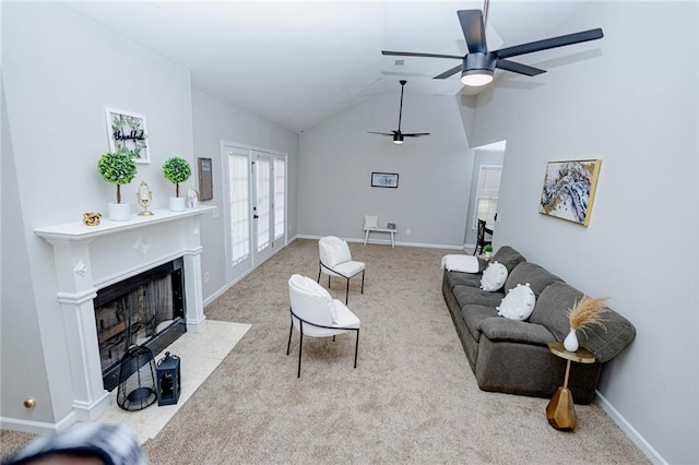 carpeted living area with a ceiling fan, baseboards, lofted ceiling, a fireplace with flush hearth, and french doors