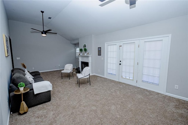 sitting room featuring lofted ceiling, a ceiling fan, carpet floors, a fireplace, and baseboards