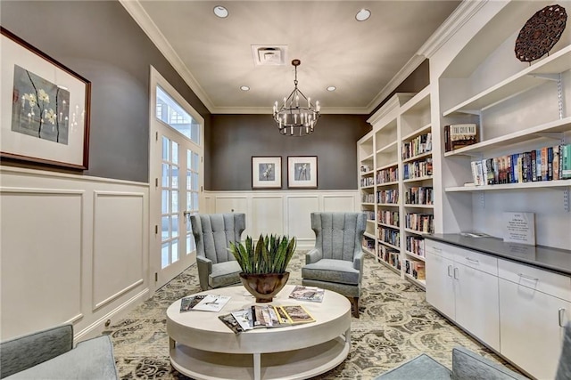 living area featuring a chandelier, french doors, and ornamental molding