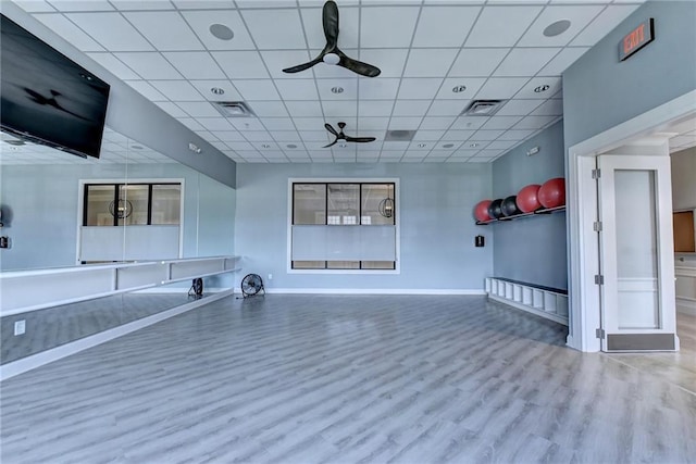 interior space featuring ceiling fan, a drop ceiling, and hardwood / wood-style flooring