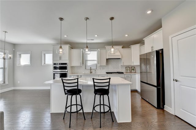 kitchen with white cabinets, a center island, sink, and stainless steel appliances