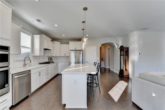 kitchen with white cabinets, sink, a kitchen island, and stainless steel appliances