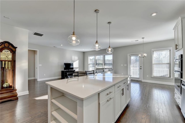 kitchen with a healthy amount of sunlight, a kitchen island, and white cabinetry