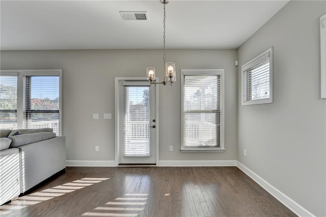 doorway with dark hardwood / wood-style flooring and an inviting chandelier