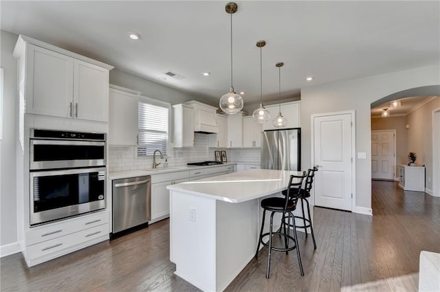 kitchen with white cabinets, appliances with stainless steel finishes, and a center island