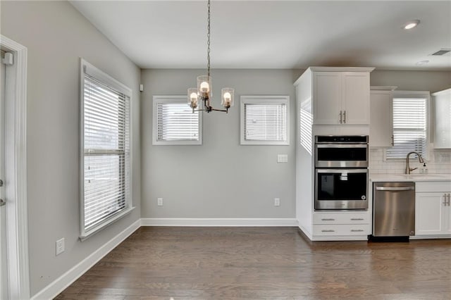 kitchen with sink, dark hardwood / wood-style flooring, decorative backsplash, white cabinets, and appliances with stainless steel finishes