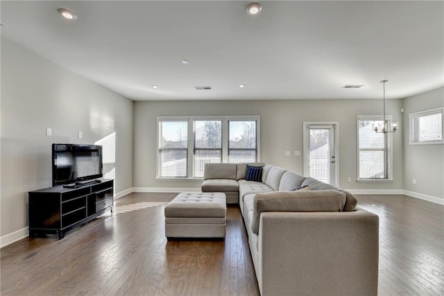 living room featuring dark wood-type flooring and a notable chandelier