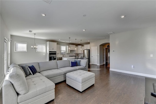 living room with an inviting chandelier and hardwood / wood-style flooring