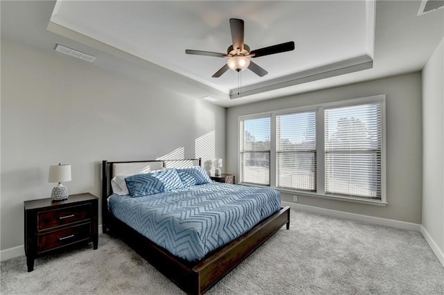 bedroom with a tray ceiling, ceiling fan, and light colored carpet