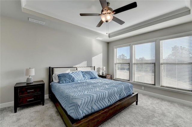 bedroom featuring light carpet, a raised ceiling, ceiling fan, and crown molding