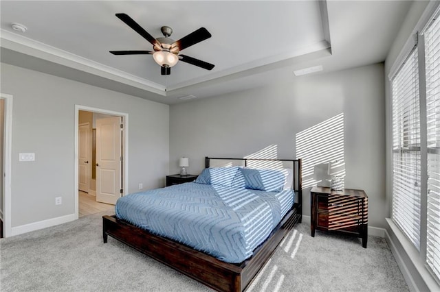 carpeted bedroom with ceiling fan and a raised ceiling