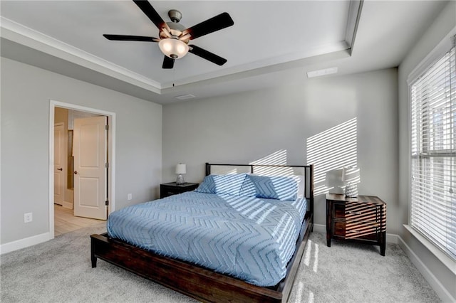 carpeted bedroom with a raised ceiling, ceiling fan, and ornamental molding