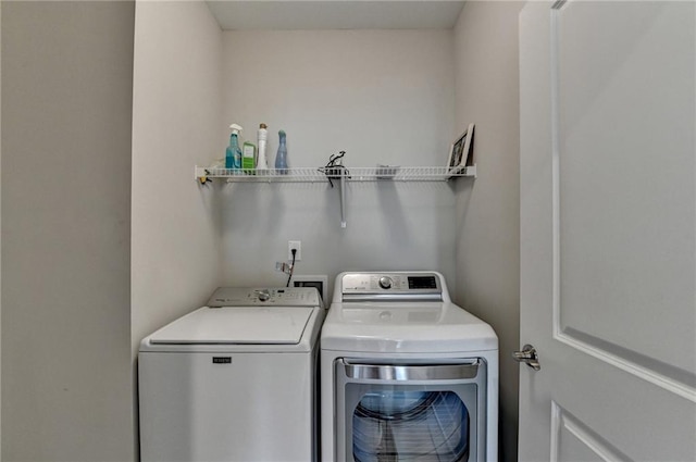 clothes washing area with washer and clothes dryer