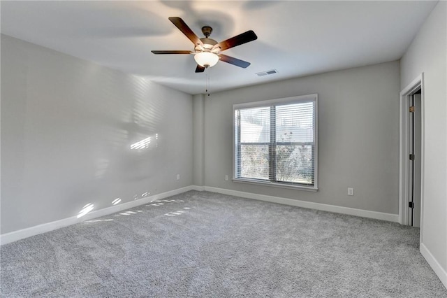 spare room with ceiling fan and light colored carpet