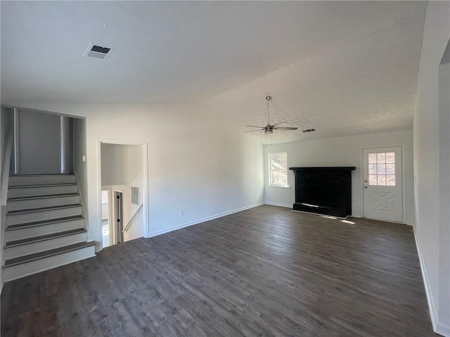 unfurnished living room with baseboards, visible vents, a ceiling fan, dark wood-style floors, and stairway