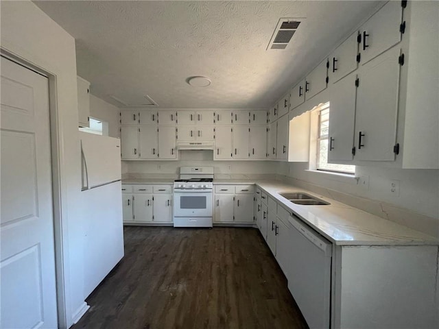 kitchen with white appliances, visible vents, dark wood-type flooring, under cabinet range hood, and white cabinetry