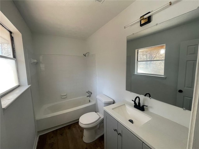 bathroom with shower / bathing tub combination, vanity, toilet, and wood finished floors