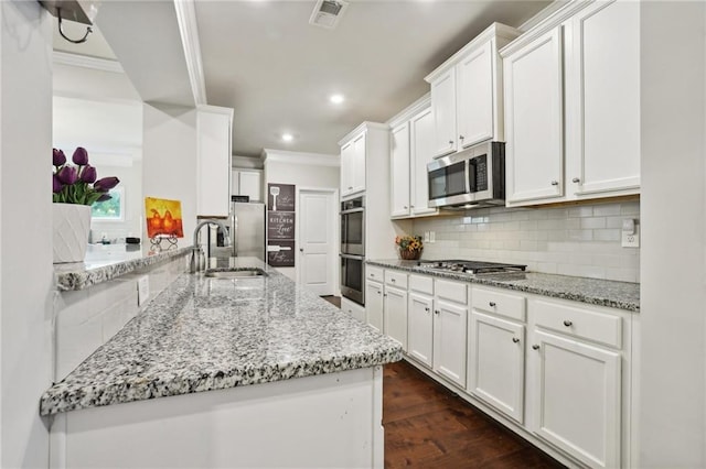 244 Lotus Cir, Mcdonough, GA 30252 - kitchen with visible vents, a sink, decorative backsplash, appliances with stainless steel finishes, and white cabinetry