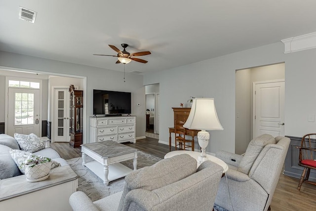 living area featuring a ceiling fan, visible vents, and wood finished floors