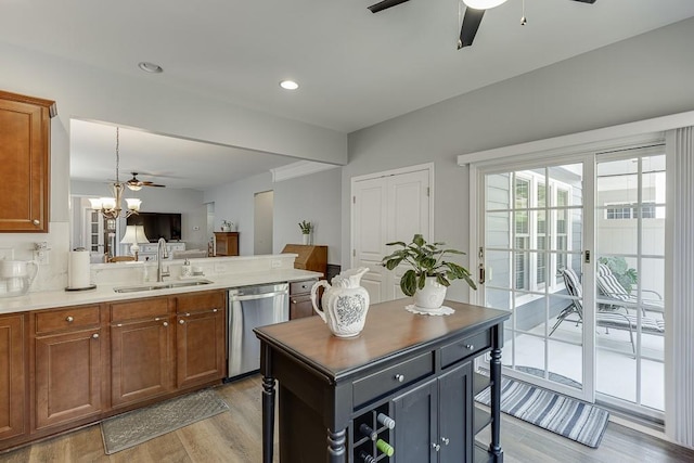 kitchen with a sink, brown cabinets, ceiling fan, light wood-style flooring, and stainless steel dishwasher