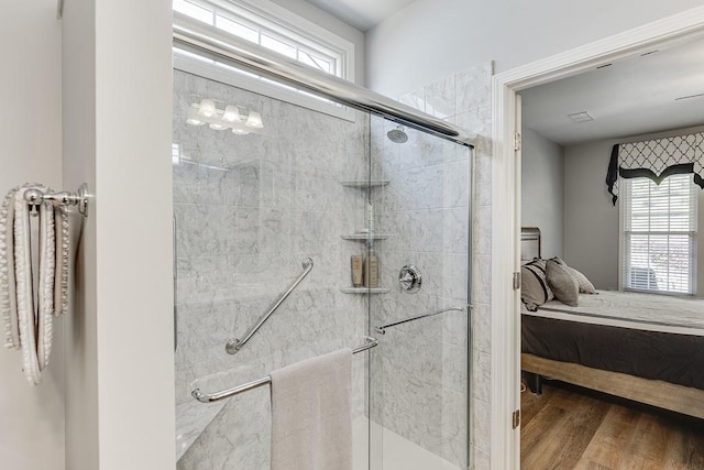 full bath featuring ensuite bath, wood finished floors, and a shower stall