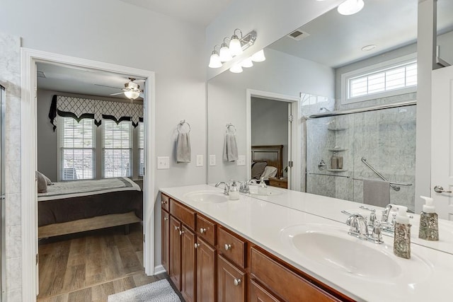 full bath with double vanity, connected bathroom, a shower stall, and a sink