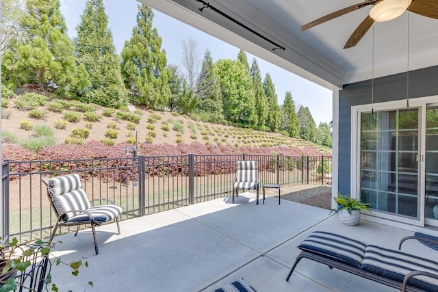 view of patio with ceiling fan and fence
