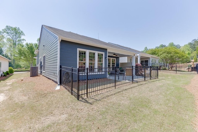 rear view of house with a ceiling fan, fence, a lawn, central AC unit, and a patio area