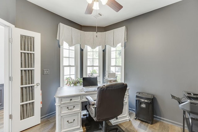 office space with a ceiling fan, baseboards, visible vents, and wood finished floors