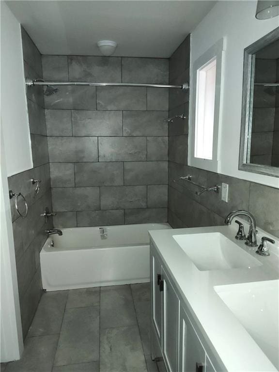 full bath featuring  shower combination, tile walls, vanity, and decorative backsplash