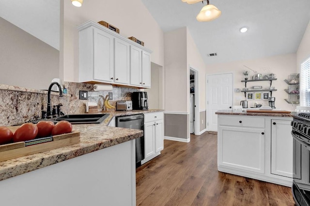 kitchen featuring dishwasher, wood finished floors, vaulted ceiling, white cabinetry, and a sink