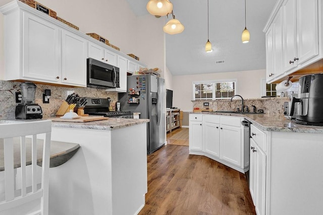 kitchen featuring a peninsula, appliances with stainless steel finishes, white cabinets, and a sink